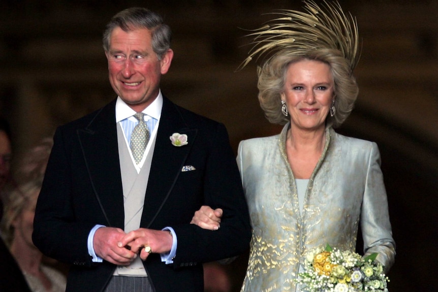 Prince Charles grins next to the Duchess of Cornwall as they leave church following their wedding.