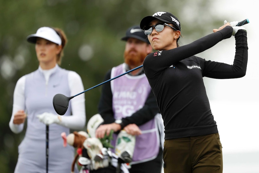 A golfer in full swing off the tee at a major championship, the Women's PGA.