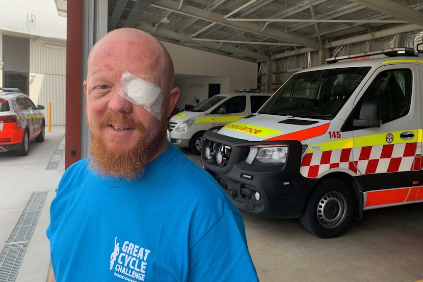 A man wearing an eye patch looks towards the camera.