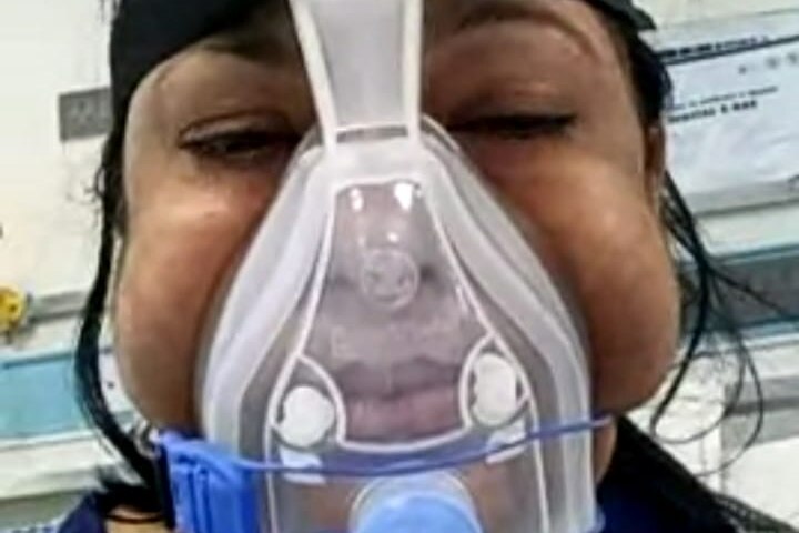 A selfie of an Indian woman with an oxygen mask pictured in a video call to her daughter. 