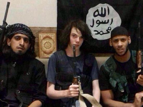 A teenager sits between two Islamic State militants.