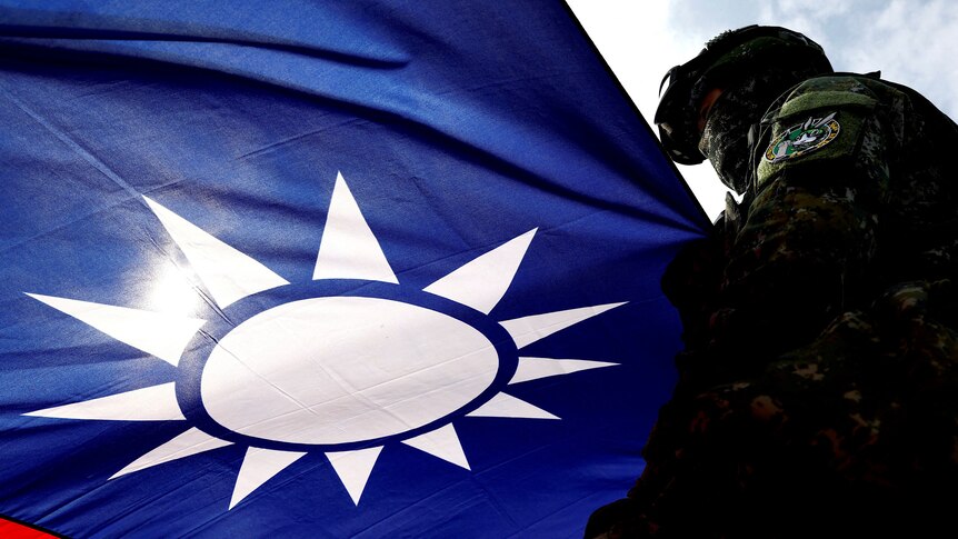 Taiwan's flag shines against a blue sky, and a solder is seen on the far right.