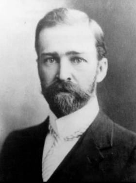A black and white photo of a balding man