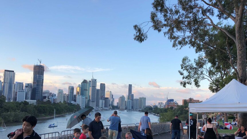 A smattering of people gathered with chairs and tents at Brisbane's Kangaroo Point cliffs.