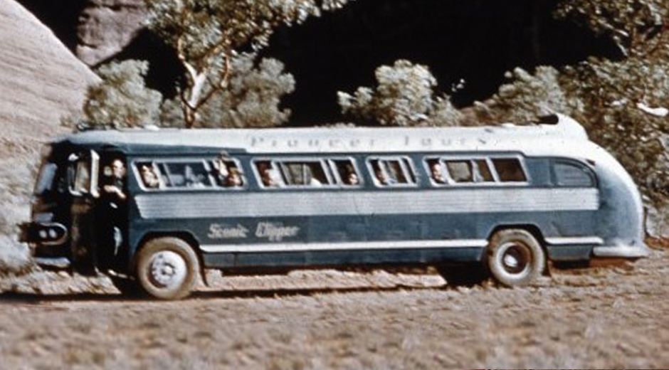 A tourist bus passes through Curtin Springs in the 1950s.
