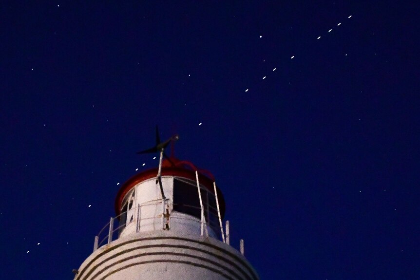 A procession of Starlink satellites in the night sky.