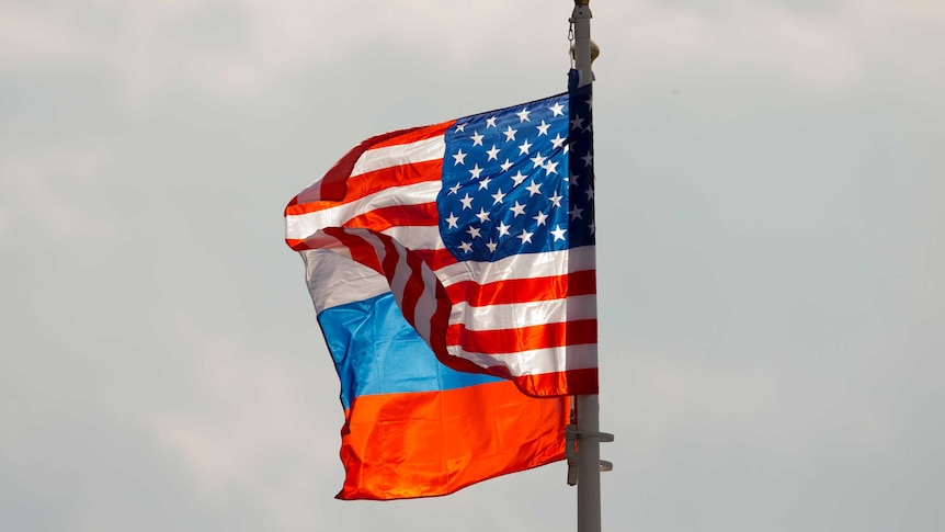 A US and Russian flag wave on the wind next to each other.