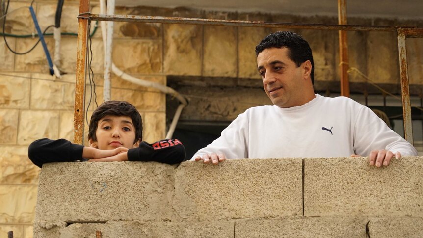 A small boy and a man on a balcony