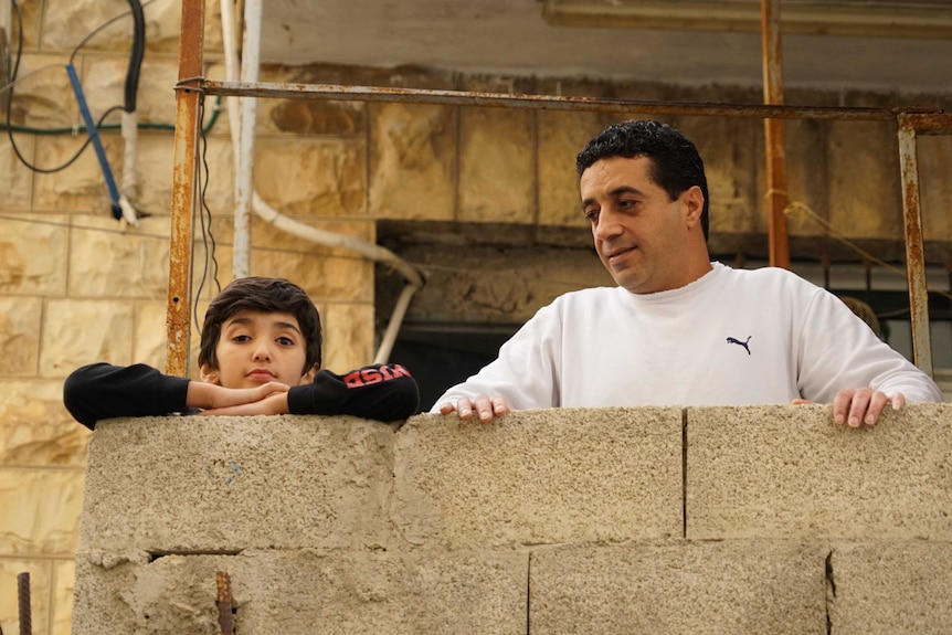 A small boy and a man on a balcony