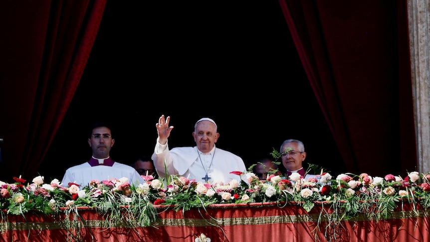 Wearing white, Pope Francis waves from balcony during religious service