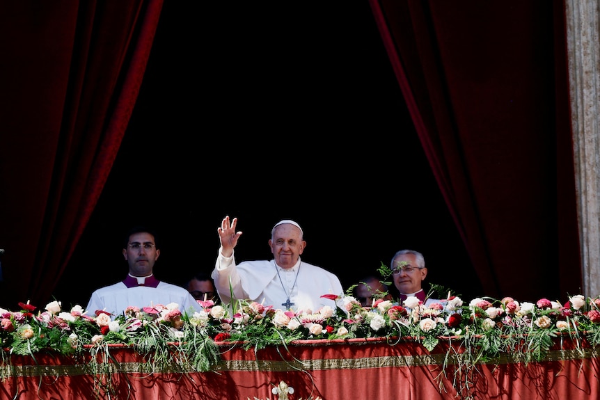 Wearing white, Pope Francis waves from balcony during religious service