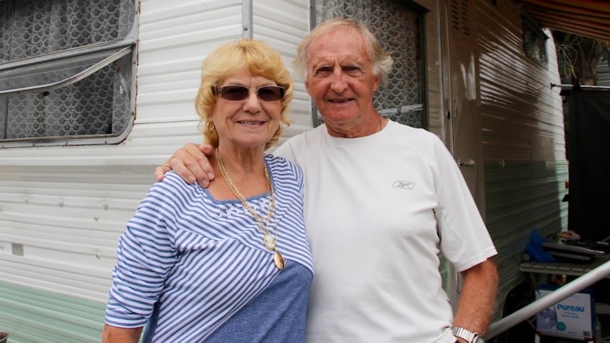 Older couple Ray and Annie Barrow standing in front of their retro caravan at Kiama caravan park