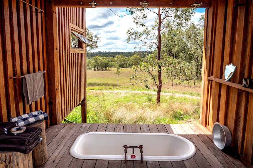 A bath that opens to a bush setting.