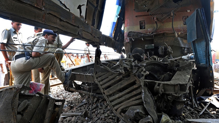 Indian officials inspect the damaged train engine after the collision