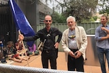 Two men standing one with flag