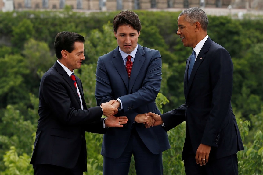 An awkward handshake between Canadian PM Justin Trudeau, Mr Obama and Mexican President Pena Nieto.