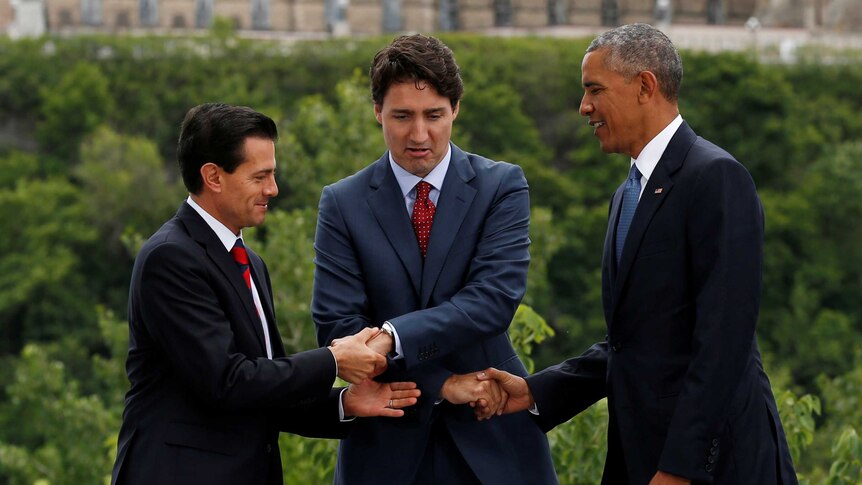 An awkward handshake between Canadian PM Justin Trudeau, Mr Obama and Mexican President Pena Nieto.