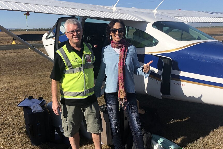 A man and a woman standing in front of a light aircraft on an airstrip in Eromanga.
