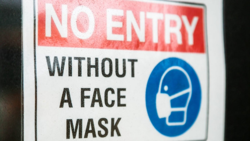 A sign pasted on a glass door saying no entry without a mask.