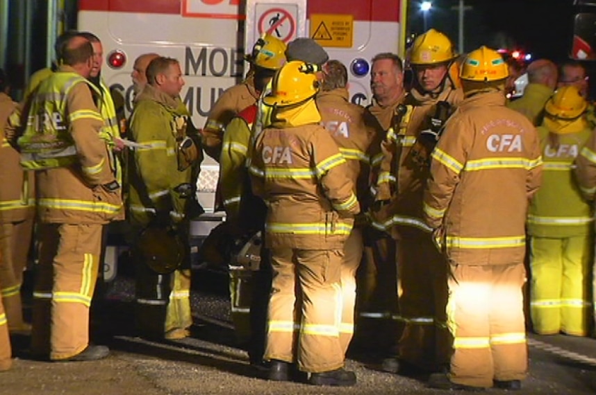 A dozen fire crews father in front of a fire truck at the scene of a fatal crash at Tyabb on Victoria's Mornington Peninsula.