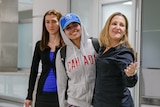 Rahaf al-Qunun wears a 'Canada' hoodie and UNHCR cap, arriving at the Toronto Airport with foreign minister Chryrstia Freeland
