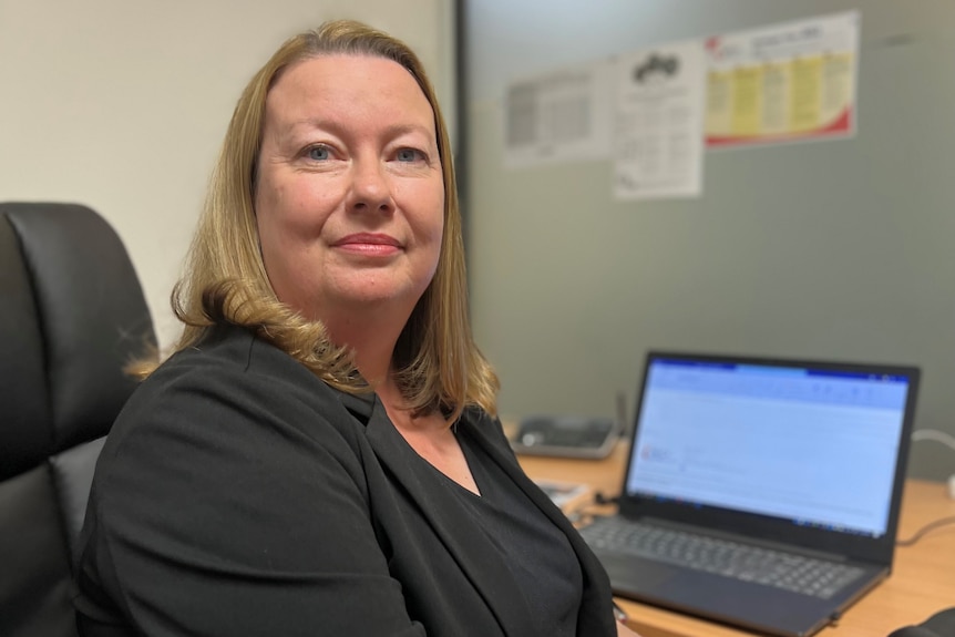 Kate Fox, from the SA Financial Counsellors Association, sits at her desk.