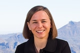 Astrophysicist Lisa Harvey-Smith sitting in front of landscape.