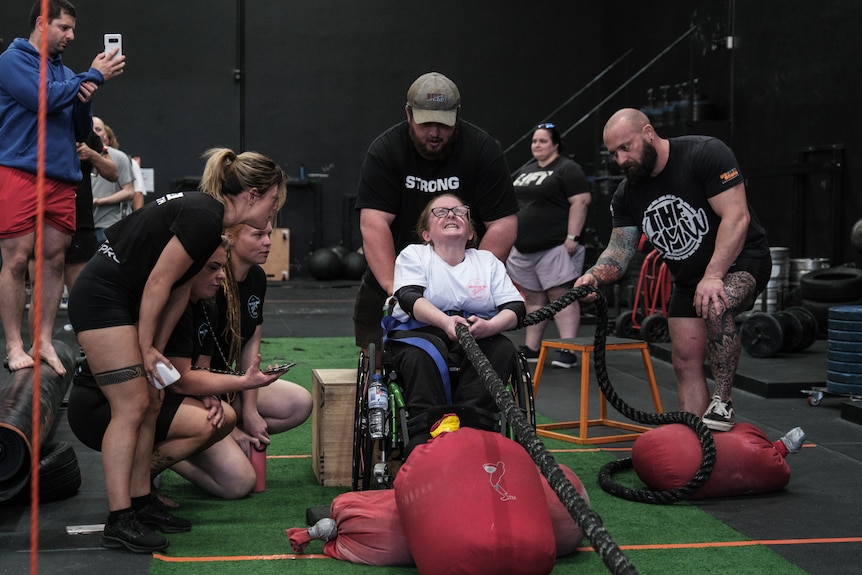 Ainslee Hooper pulls a rope while in her wheelchair.