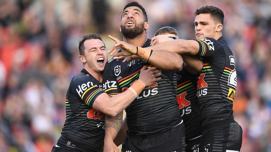Viliame Kikau points and looks to the sky as he celebrates a Panthers try with his teammates.