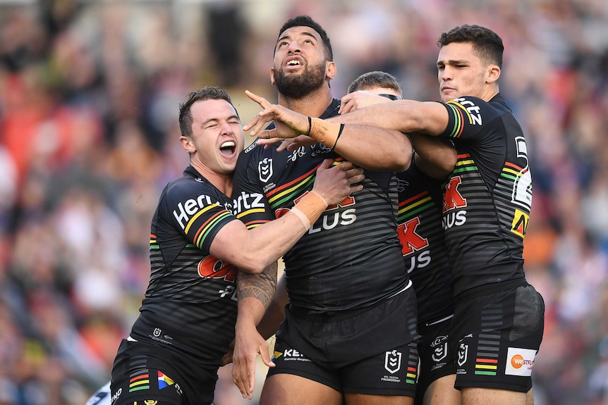 Viliame Kikau points and looks to the sky as he celebrates a Panthers try with his teammates.