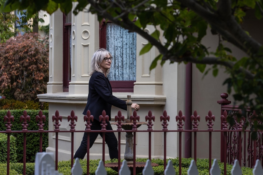 A woman walking towards a house.