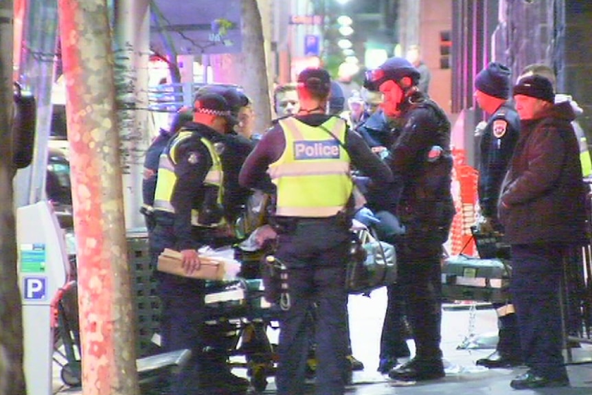 Police around an ambulance stretcher outside a nightclub in King Street in Melbourne's CBD after two people were shot.