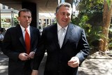 Wide photo of Tony Abbott (left) and Joe Hockey walking outside. Joe with big grin, Oct. 2, 2007,