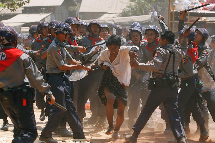 Police clash with a protester in Myanmar