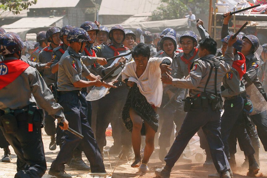 Police clash with a protester in Myanmar