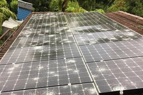 Solar panels on a rooftop are cracked from falling hail.