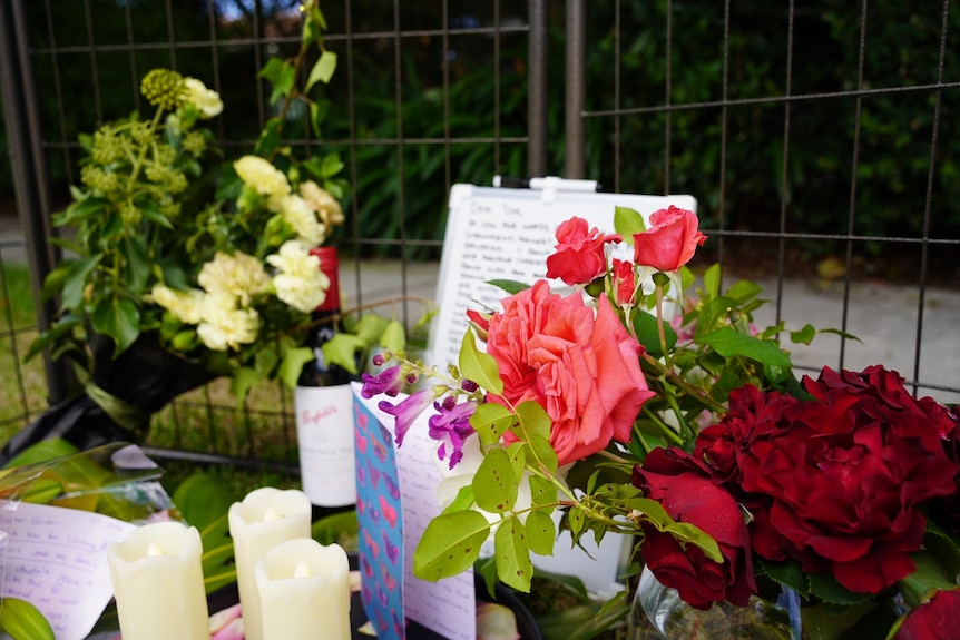 Pink roses and a heartfelt message written to the victim of the attack surrounded by a mural.