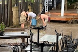 people cleaning up after their business was flooded in Samford