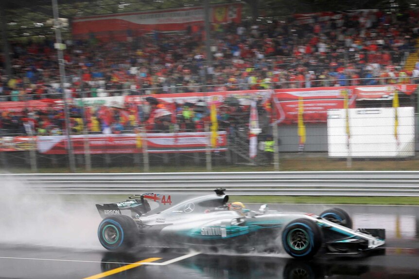A Formula One car races in the rain at the Italian Grand Prix.