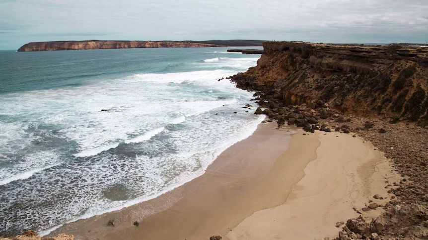 A dramatic coastline featuring turquoise waters and clean sand.