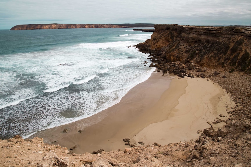 A dramatic coastline featuring turquoise waters and clean sand.