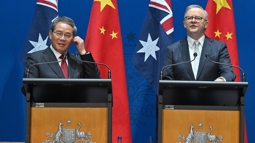 Li Qiang and Anthony Albanese speaking at podiums in front of the China and Australian flags