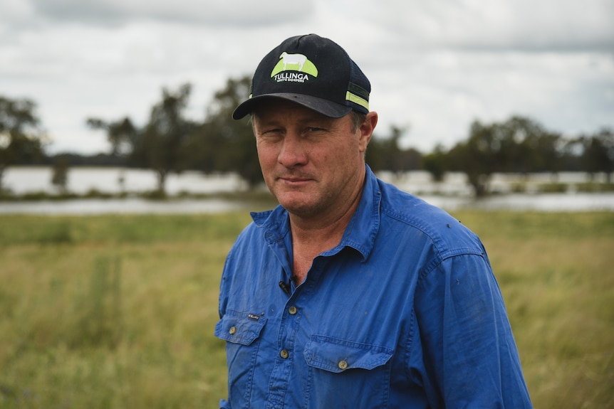 A man in a blue shirt and black cap.