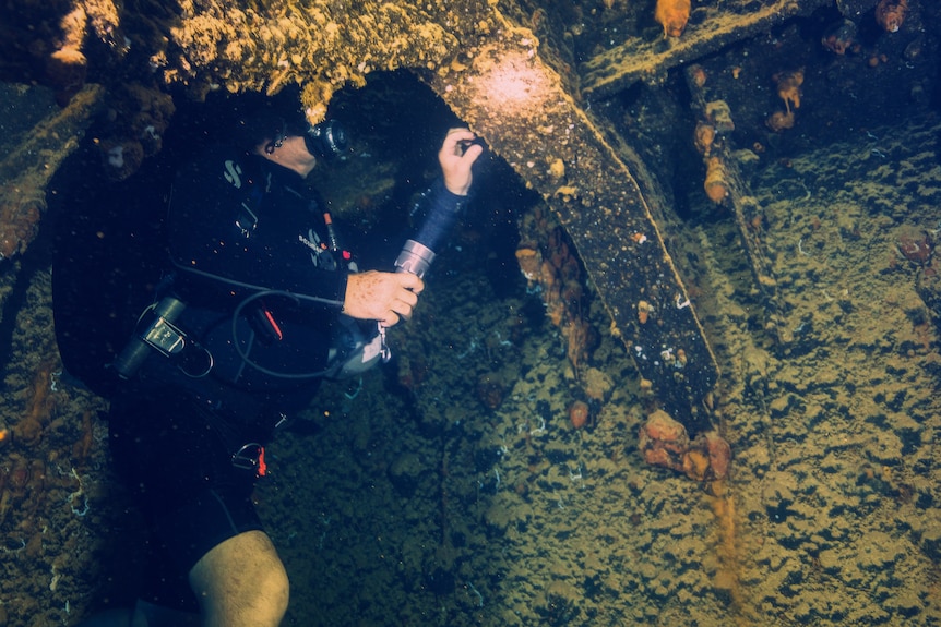 A diver inside an empty fuel bunker. 