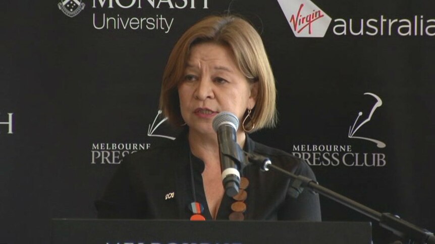 Michelle Guthrie smiling in front of a Melbourne Press Club sign.