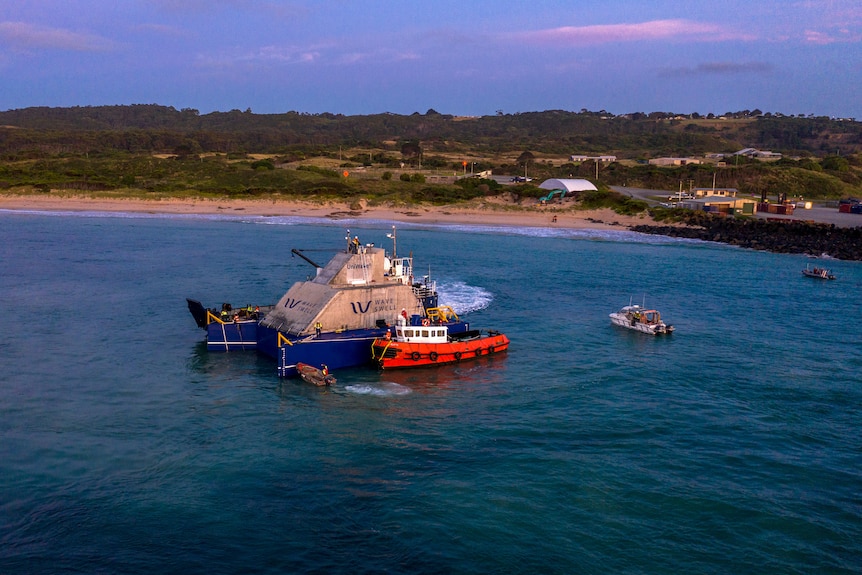 A tug boat alongside the UniWave200 power generator.