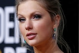 A headshot of Taylor Swift, hair pulled back, at the Golden Globes.