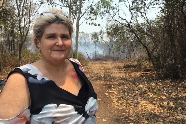 Sarina beach resident Vicky Crichton standing on her property with smoke in the background.