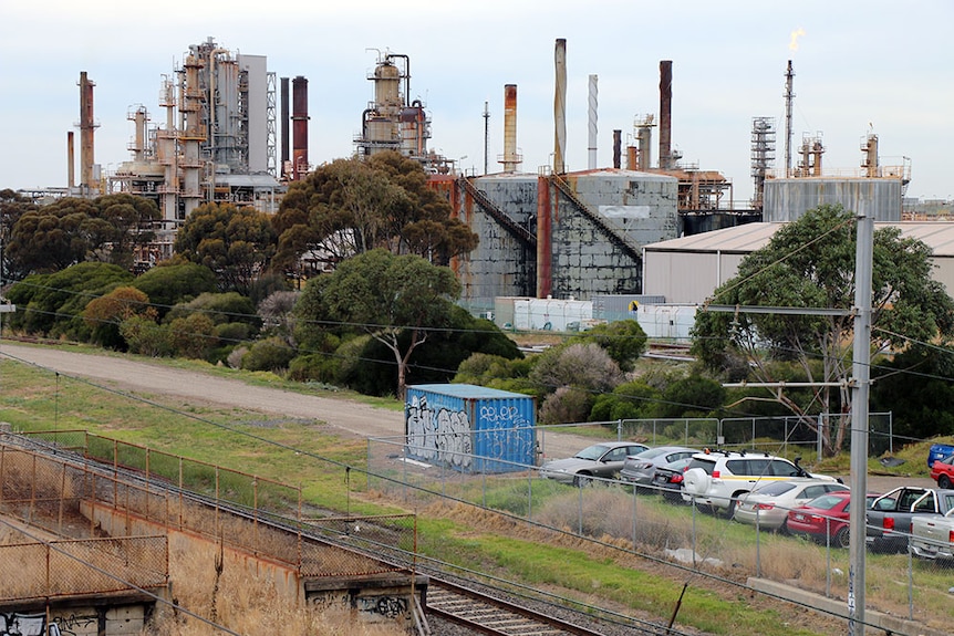 A row of trees surround the Altona Refinery in Melbourne.