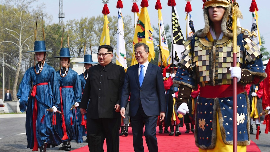 Kim Jong-un (left) and Moon Jae-in walk together at the border village of Panmunjom.